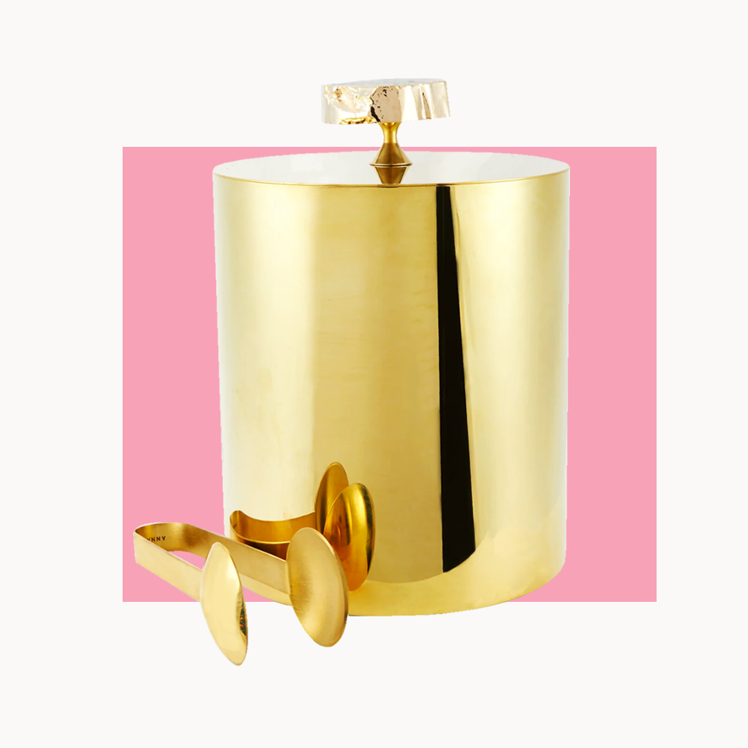 a gold ice bucket with gold tongs on a white background
