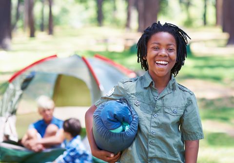 teenager in front of a camping tent