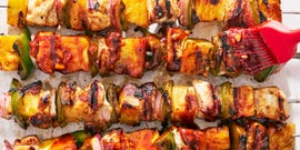 chicken, pineapple, and peppers on a skewer basted with teriyaki