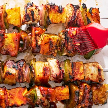 chicken, pineapple, and peppers on a skewer basted with teriyaki