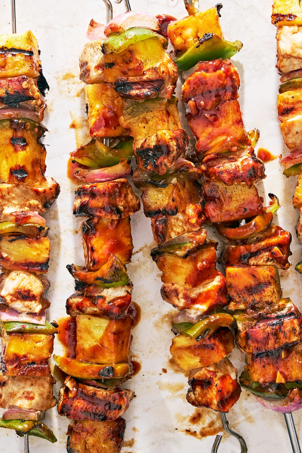 chicken, pineapple, and peppers on a skewer basted with teriyaki