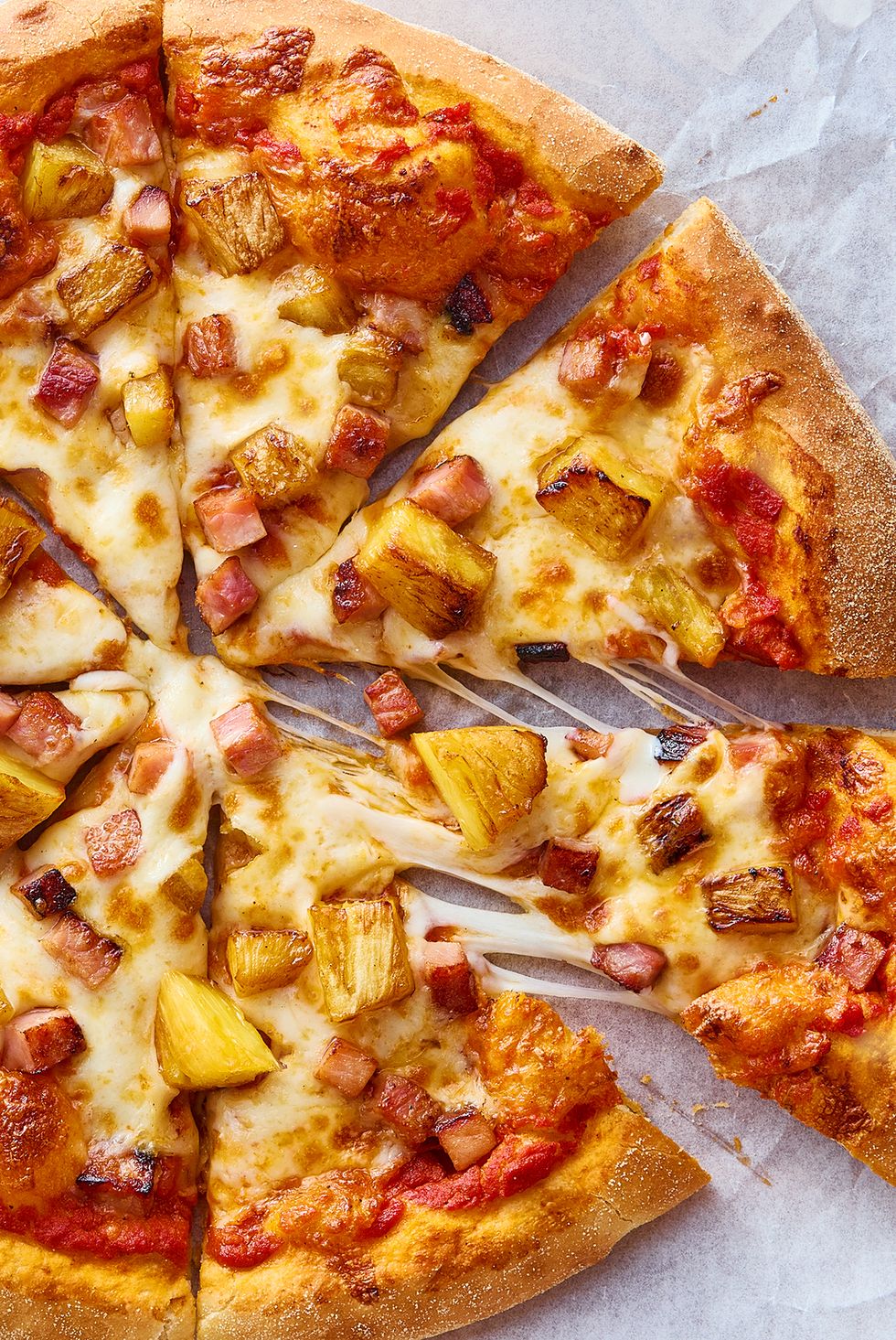 pizza topped with pineapple and pieces of ham