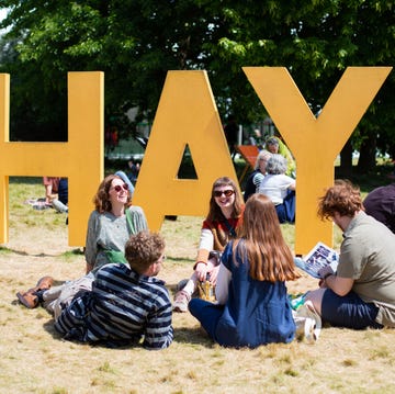 Best book festivals large yellow letters spelling hay with people sitting around on grass