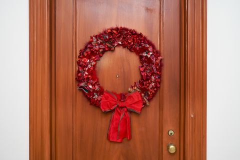 a brown door with a red christmas wreath