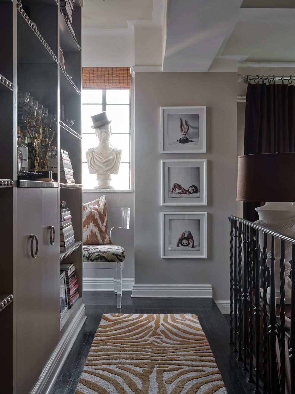 entryway with an animal print runner, art on the wall and cabinets on the side