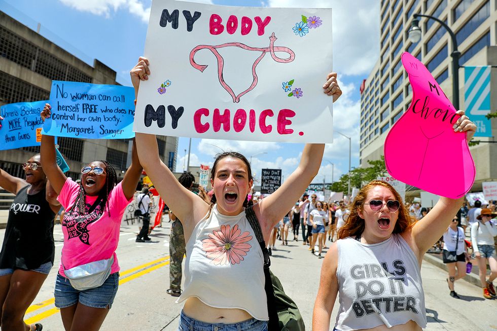 demonstrators hold signs while marching during a protest against georgia's "heartbeat" abortion bill in atlanta, georgia, us, on saturday, may 25, 2019 people gathered to protest the state's recently passed house bill 481, which would ban abortion after a doctor can detect a fetal heartbeat  usually around the sixth week of pregnancy photographer elijah nouvelagebloomberg via getty images