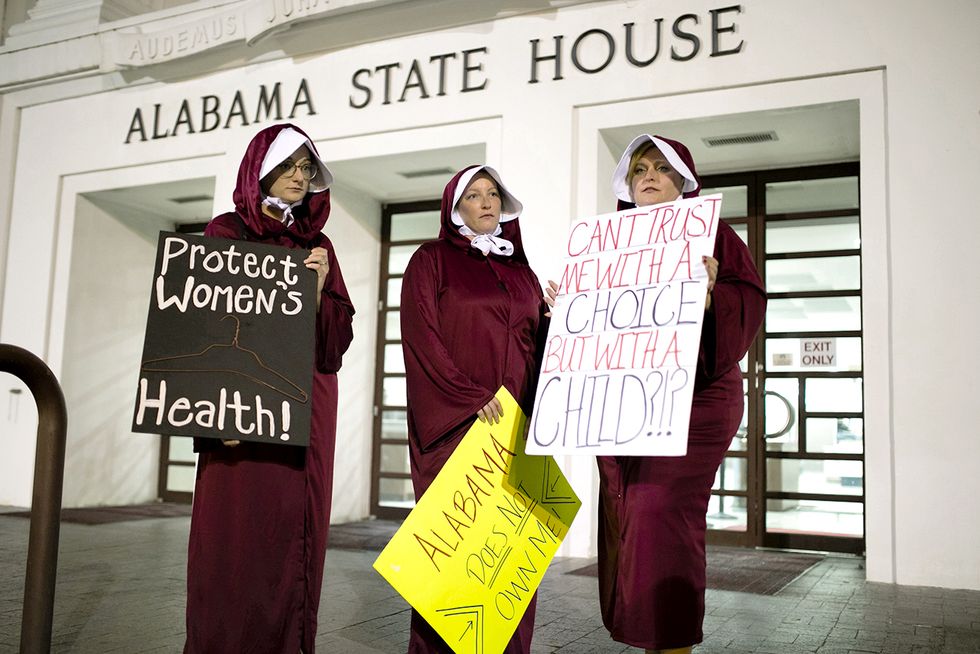montgomery, al   may 14  women wearing handmaid costumes protest in front of the alabama state house after the state senate passed hb314, which banned abortions in all cases except the health of the mother in the alabama state house on tuesday, may 14, 2019 in montgomery, al photo by elijah nouvelage for the washington post via getty images