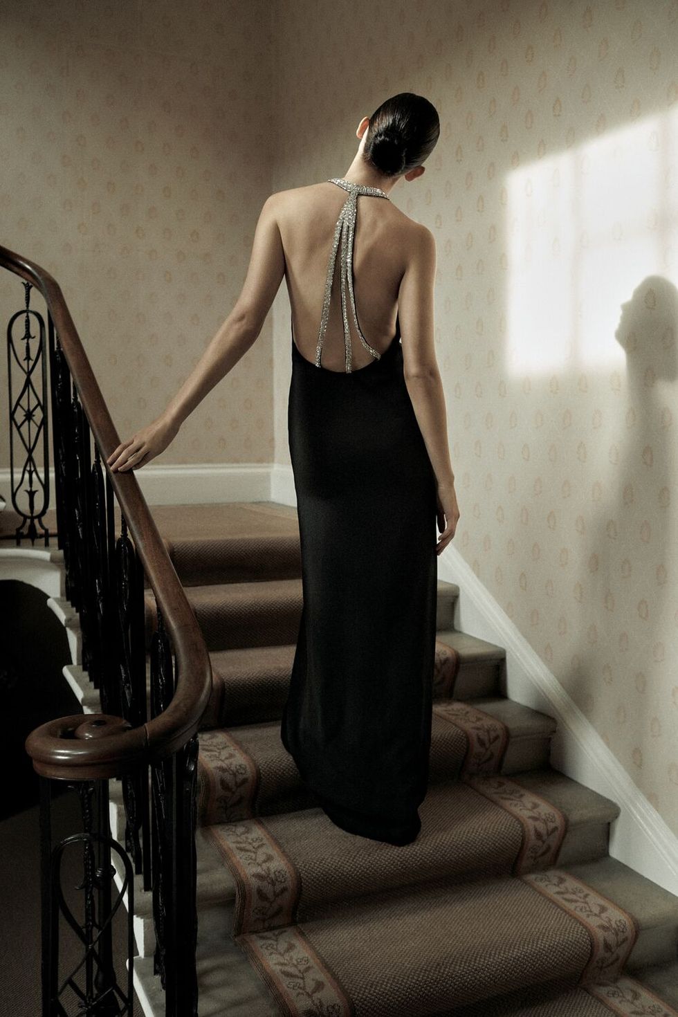a person in a dress standing on a staircase
