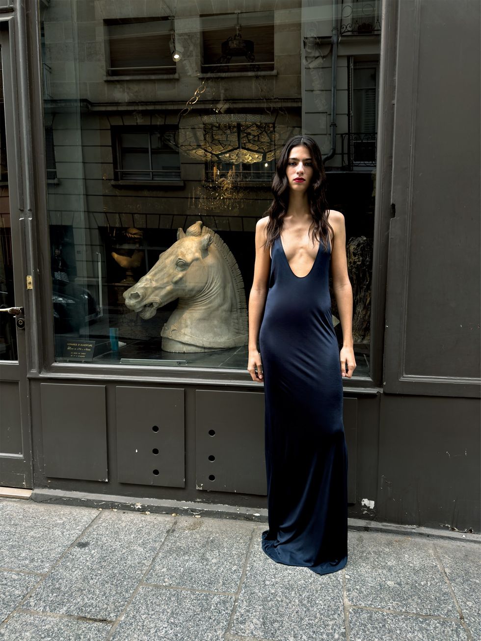 a woman posing in front of a window with a statue of a lion