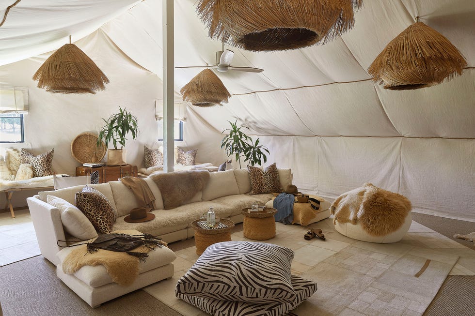 a tentlike living room with a couch and a table and cushions