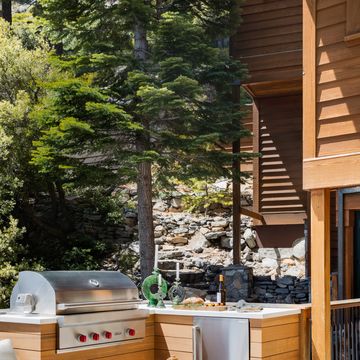 a corner cabinet and undercounter fridge boost the utility of this grilling area by designer jen samson