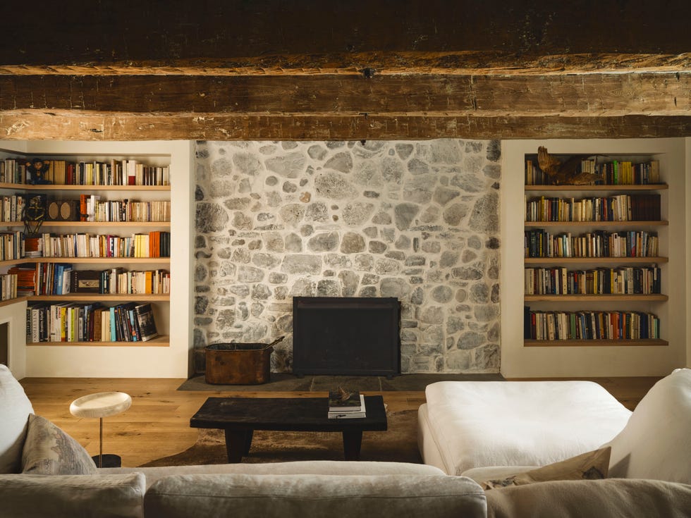 salón con chimenea y pared de piedra