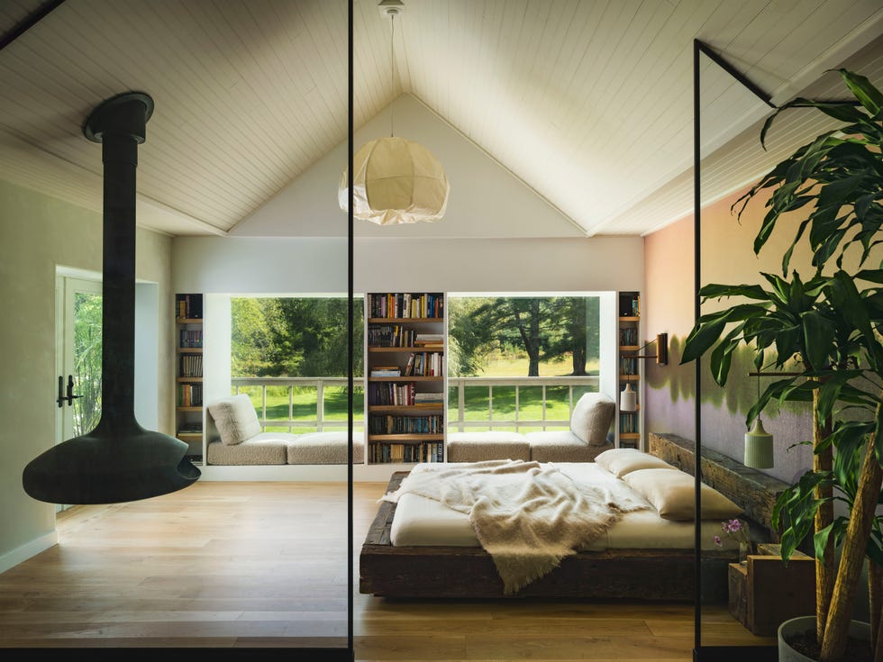 dormitorio moderno con ventanales y chimenea suspendida