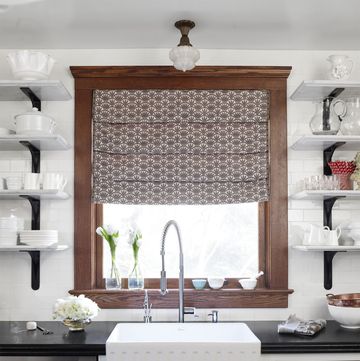 kitchen sink below brown window with pattern curtains
