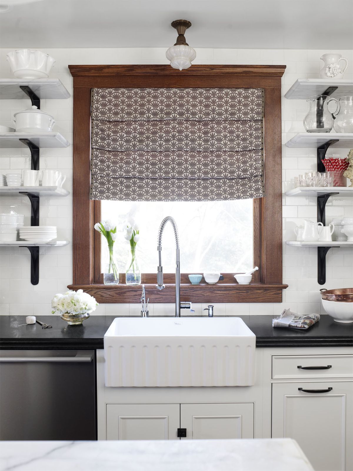 kitchen sink below brown window with pattern curtains