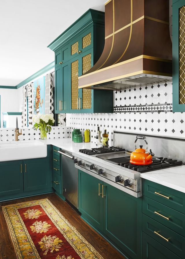 green kitchen, green cabinets, orange kettle, black and white backsplash