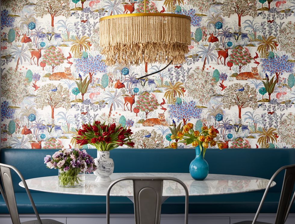 dining room with banquette and patterned wallpaper