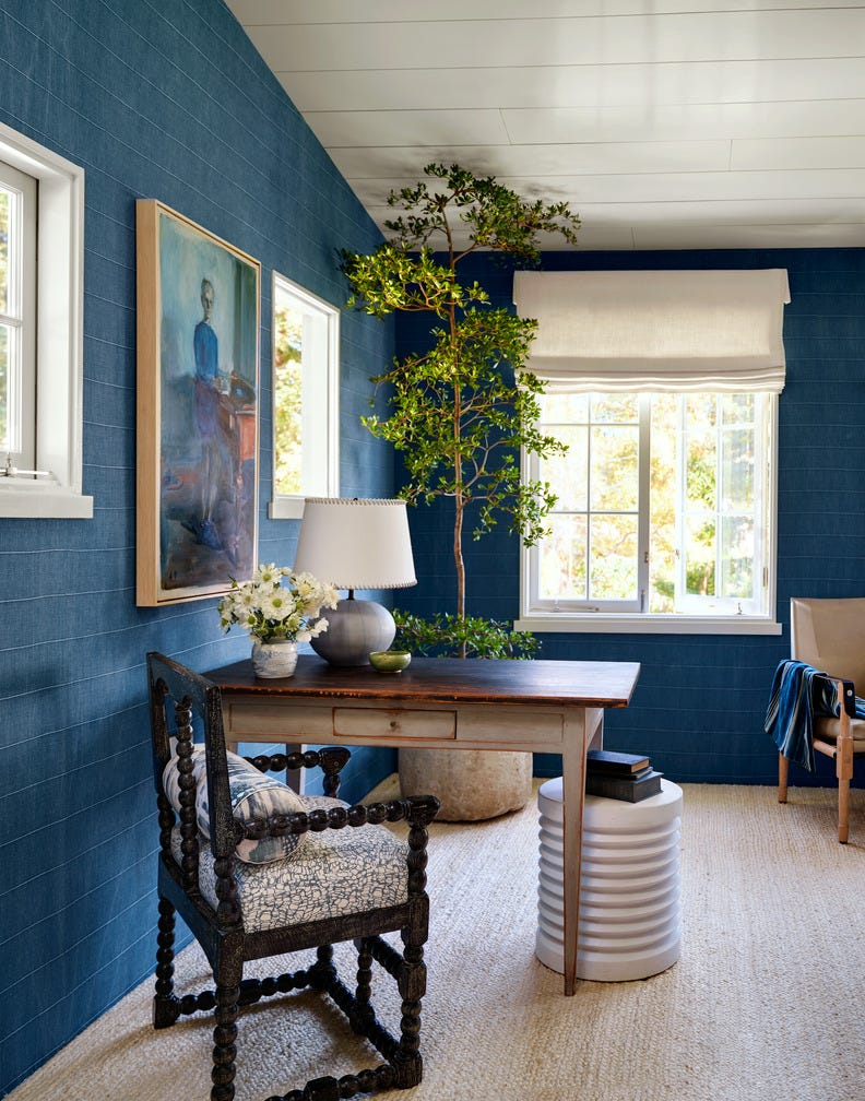 This American Colonial Revival style home was built by interior designer Jeffrey Alan Marks near Butterfly Beach in Montecito, California. The wallpaper in the master bedroom is Faso fabric with backing; the shade fabric is by Rose Tarlow, Otis Textile; the desk is 19th century Swedish; the chair is antique, from Leaf Gallery; and the side table is by Palecek, Rugstag.