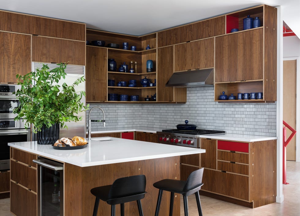 The kitchen cabinets are custom walnut and laminate, the Karf Design stoneware is client owned and handmade in the 1970s, the tiles are Ann Sacks, the counter stools are Mutt Range, the Wolf Wine fridge is Electrolux and the wall oven is Bosch