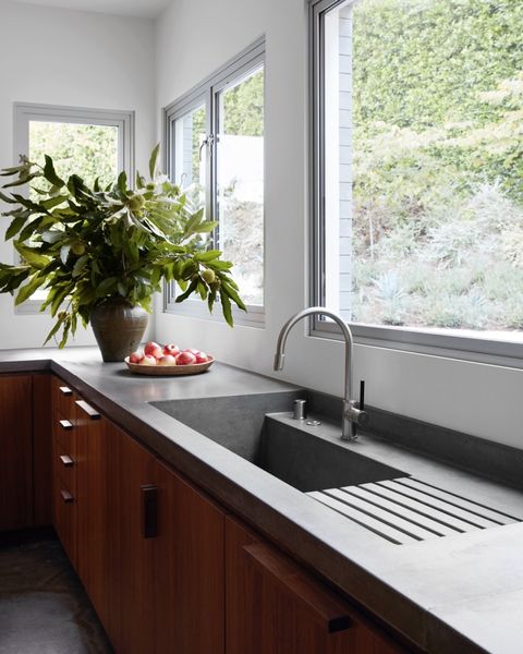kitchena custom concrete counter includes a built insink and dish drainer faucet vola