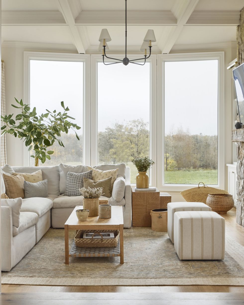 living room with floor to ceiling windows looking out to a green field