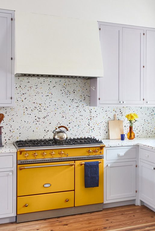 cabinets painted in soft and subtle calluna by farrow  ball complement the citrus yellow lacanche range and rainbow terrazzo counters in this manhattan kitchen designed by penelope august