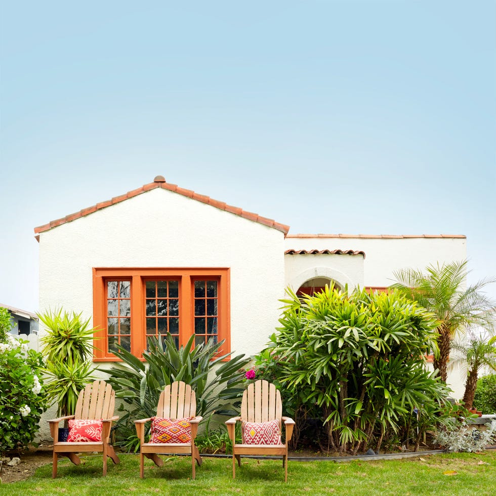a house with chairs and plants in front of it