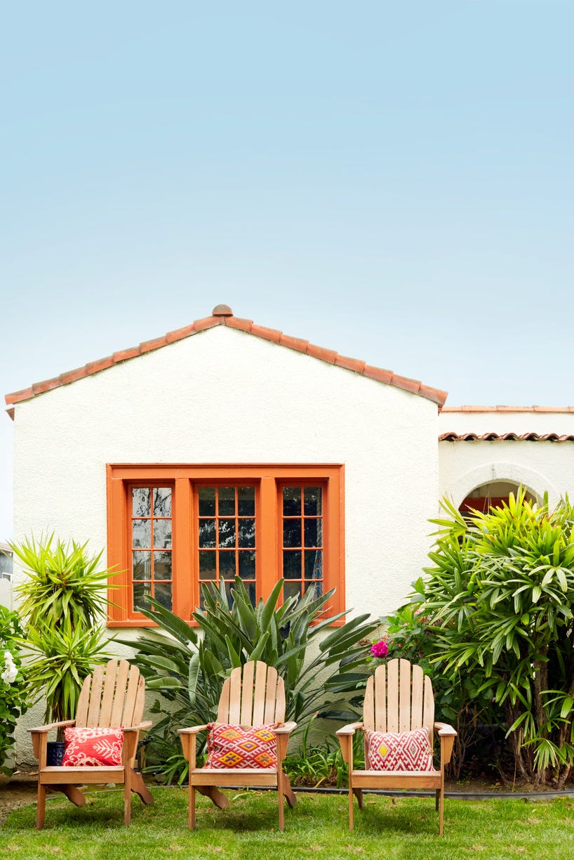 a house with chairs and plants in front of it