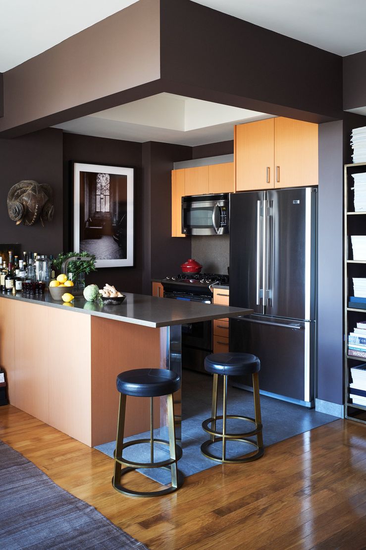 a kitchen with a bar stool and a refrigerator