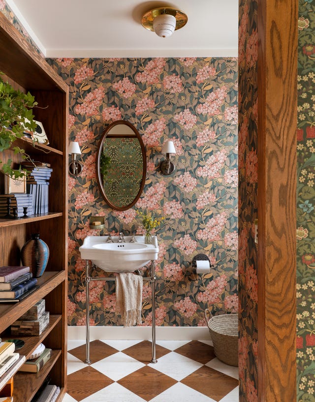 a bathroom with pink wallpaper and painted checkerboard floor