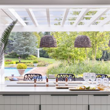 open bar with the windows folded open, adults can keep an eye on swimming kids—and easily pass through snacks drinks are sunk into a slim trough cut into the countertop and stocked with ice pendants lightology chairs janus et cie hardware rocky mountain hardware