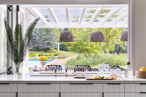 open bar with the windows folded open, adults can keep an eye on swimming kids—and easily pass through snacks drinks are sunk into a slim trough cut into the countertop and stocked with ice pendants lightology chairs janus et cie hardware rocky mountain hardware
