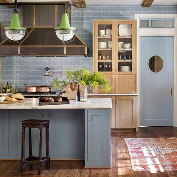 kitchen because this room sits at the center of the home, mcbrearty’s clients “wanted an unassuming feeling of warmth” door and island paint normandy, benjamin moore tiles waterworks hood custom, lacanche stools vintage, robuck rug antique, client’s own pendants the urban electric co beams reclaimed barnwood, the global craftsman