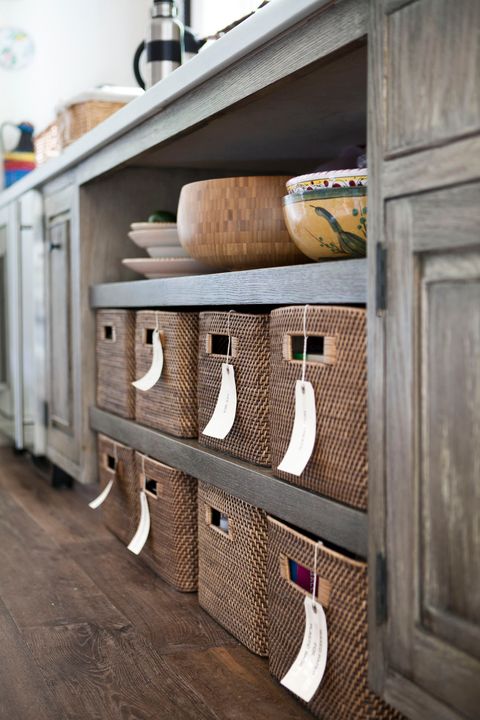 designer christopher barrett used baskets with handwritten labels to turn two open shelves into a tidy undercounter pantry