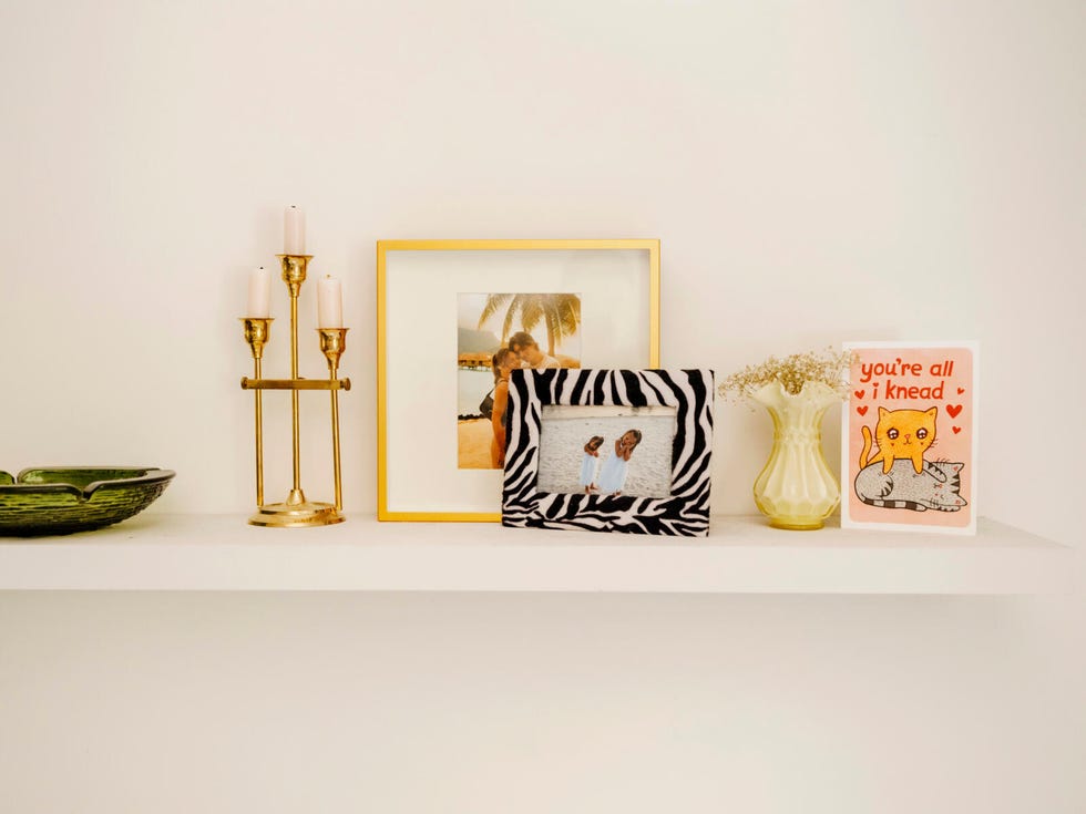 a shelf with candles and pictures on it