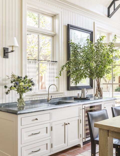 white cabinets, black countertops, vase with flowers