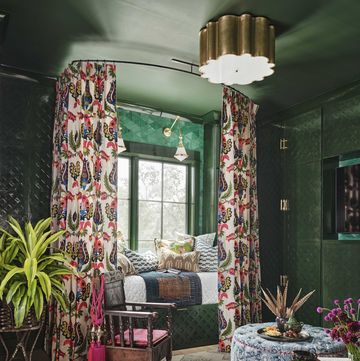 media room, day bed, floral curtains, green wallpaper, blue and white coffee table, indoor plants