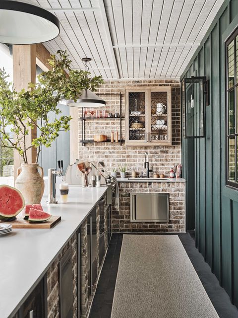 outdoor kitchen, white countertop, brick wall, green wall,