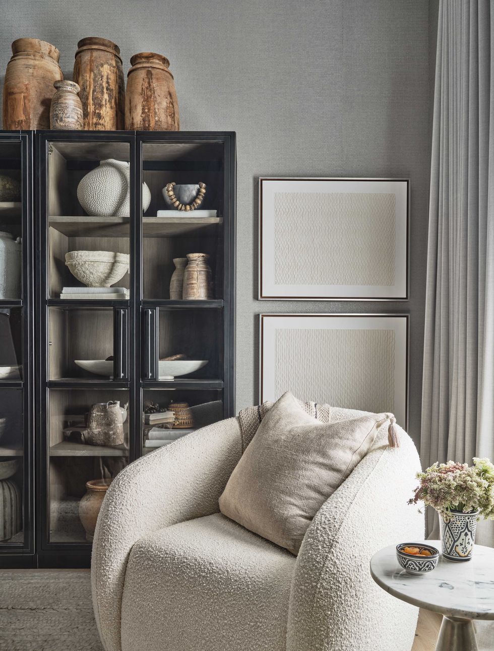 white lounge chair, black bookcase, wooden vases