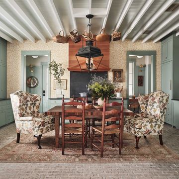 green kitchen, green cabinets, floral dining chairs, wooden table and wooden dining chairs, weaving baskets, wooden ceiling beams