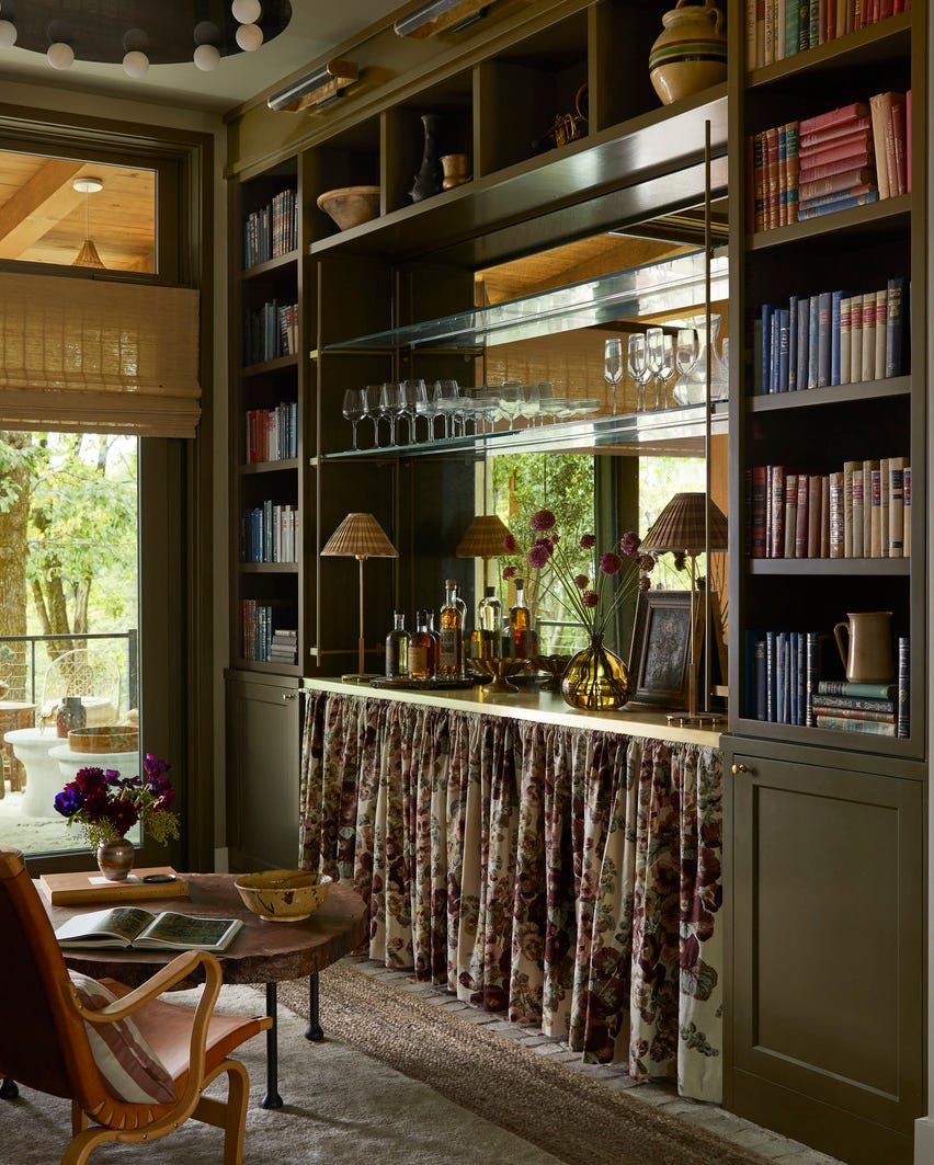 reading room anne mcdonald design annemcdonalddesign intimate, cozy retreat, custom millwork, luxurious solitude, antiqued mirror and brass shelf brackets from architectural grille, floating shelves, the bottom half of the built in is dressed with a floral skirt, softening the boxy architecture of the petite space tactile elements, like a midcentury chair, 1970s limestone console, and silky goat hair rug, encourage guests to cross the threshold to top it all off, a visual comfort co chandelier with alabaster globes adds a touch of vintage glamour overhead balancing the hard and soft here was all about a curated mix of textures shelf hardware brackets and cafe curtain rod architectural grille lighting visual comfort co shades hunter douglas drapery clarence house rugs safar top, fibreworks bottom whole home 2024 this years energy efficient home is in the conservation minded community of sprout, located on a private nature preserve in hendersonville, north carolina