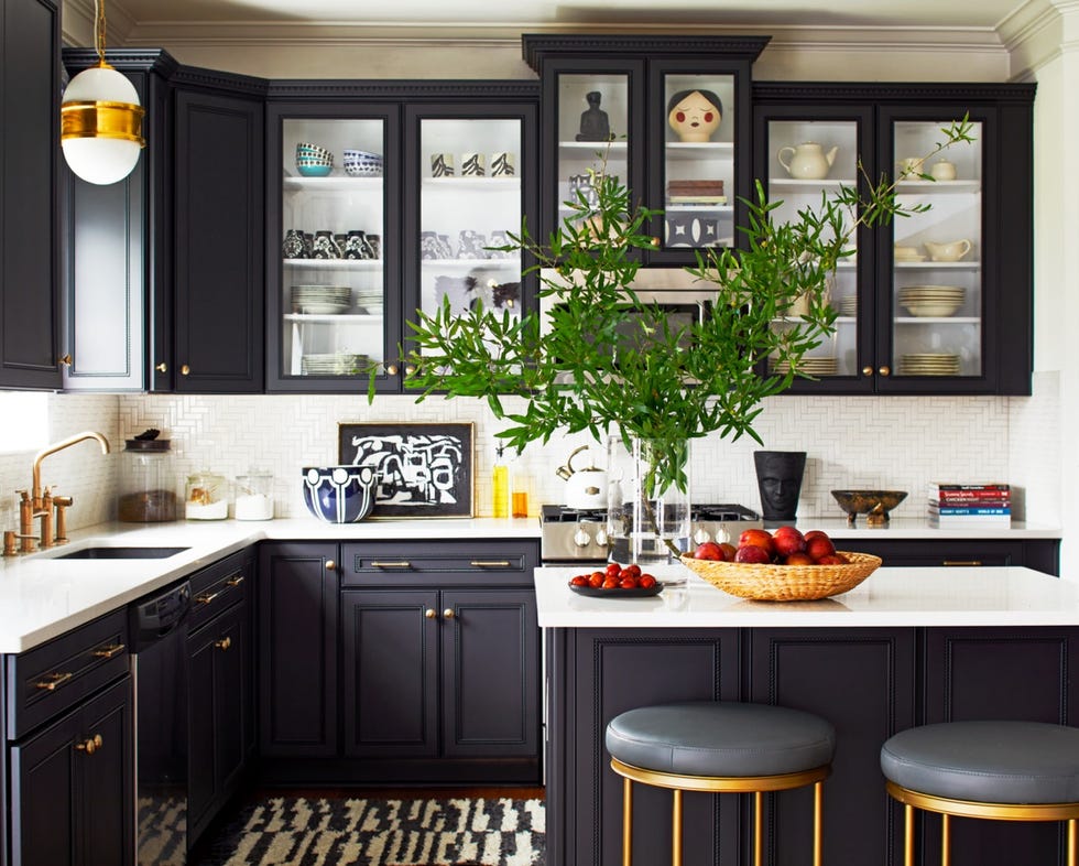 Herringbone tile shop in the kitchen of designer Arienne Beshear's Charlotte, N.C., home. She installed sideways stools, Ballard Designs lights, a Corvette rug, Loloy hardware, an Emtech sink, Elkay cabinets, and Merillat.