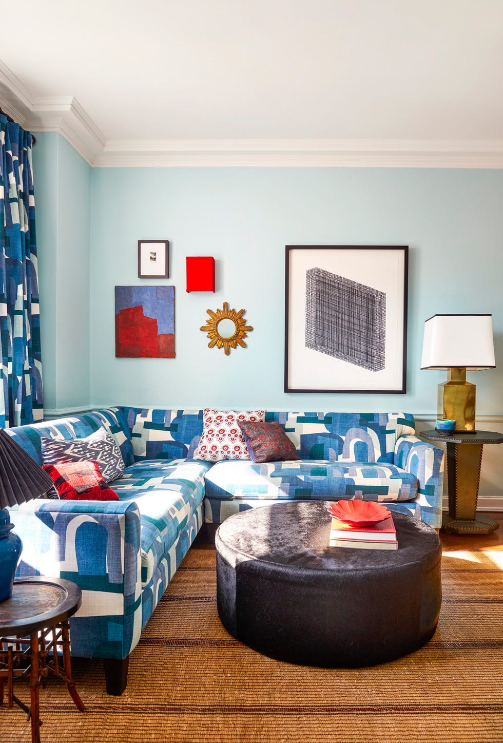 chicago, il apartment of devin kirk, vp of merchandising at jayson home. family room. paint: bird’s egg, benjamin moore. sectional: jayson home in robert allen schiele arch fabric. ottoman: jayson home. mirror and lamp: vintage. family room. wall paint: bird’s egg, benjamin moore. table: eero saarinen. wood chair: vintage italian in miles redd for schumacher fabric. butterflies: deyrolle. settee: jayson home.