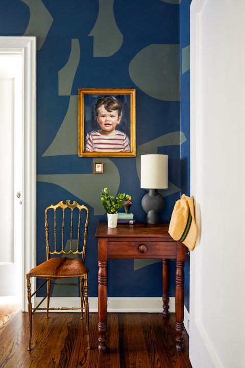 chicago, il apartment of devin kirk, vp of merchandising at jayson home hallway farrow ball stiffkey blue and studio green portrait isabelle lane mason side table scout chicago lamp and vintage chair jayson home