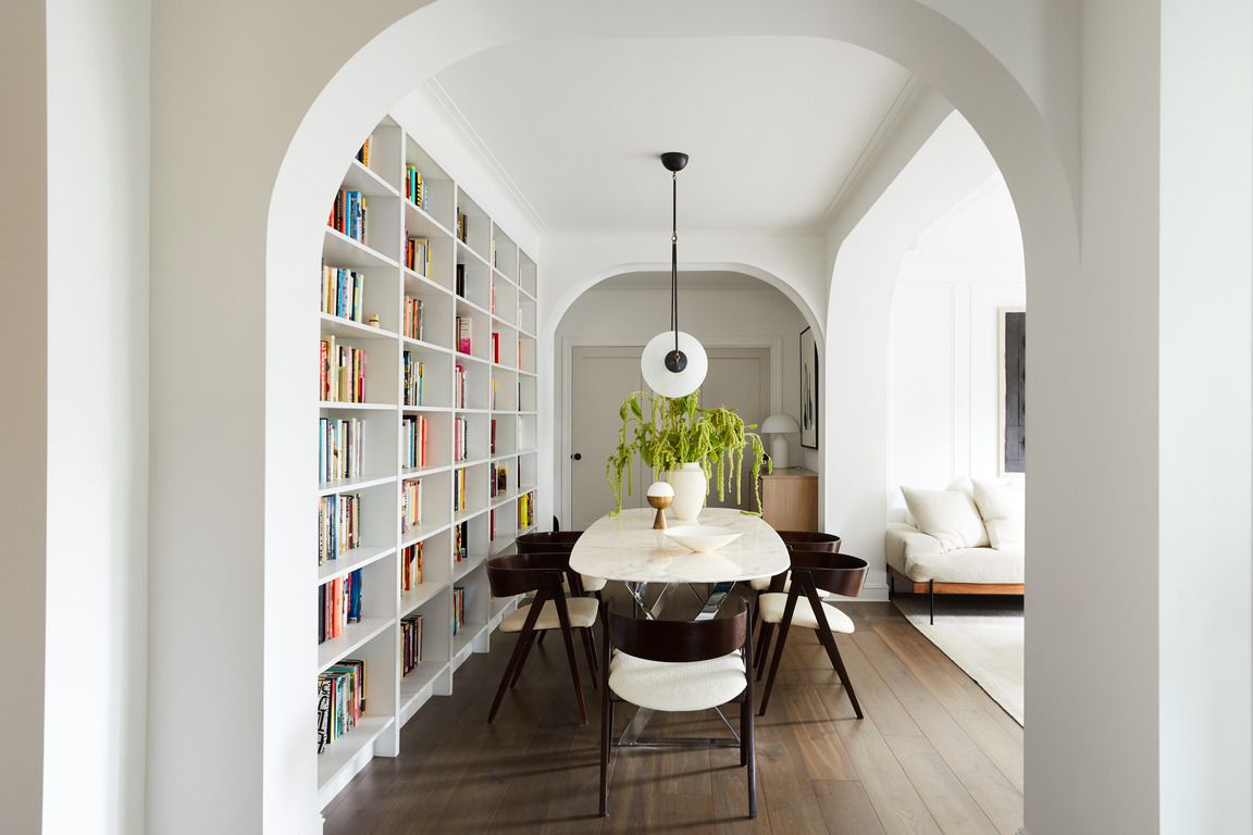 home library in brooklyn apartment designed by space exploration featuring a wall of books framed by arches