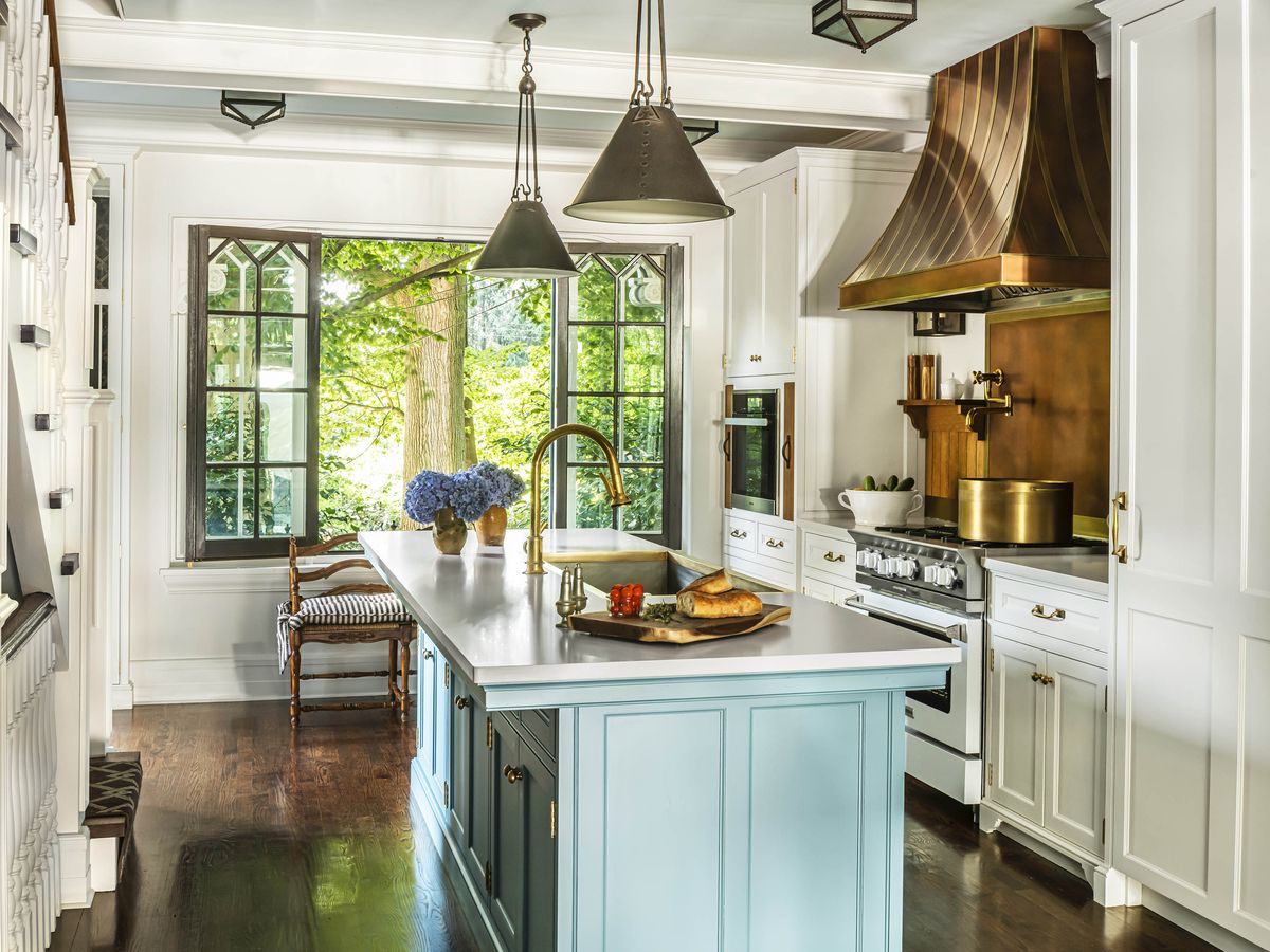 white kitchen with copper hood and blue island