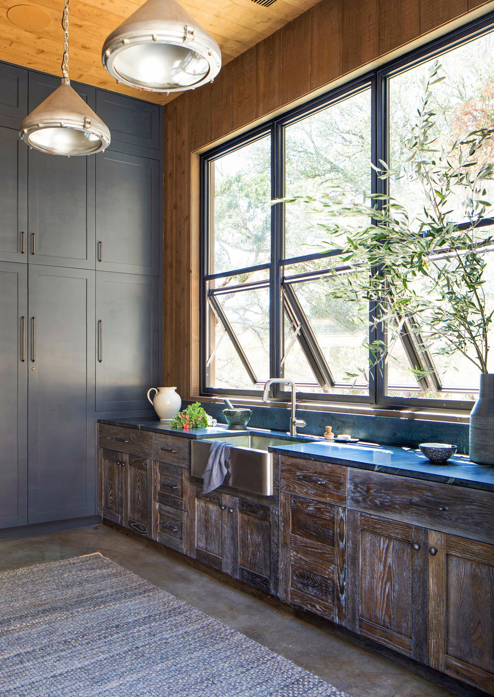 kitchen sink, wooden cabinets, and windows propped open