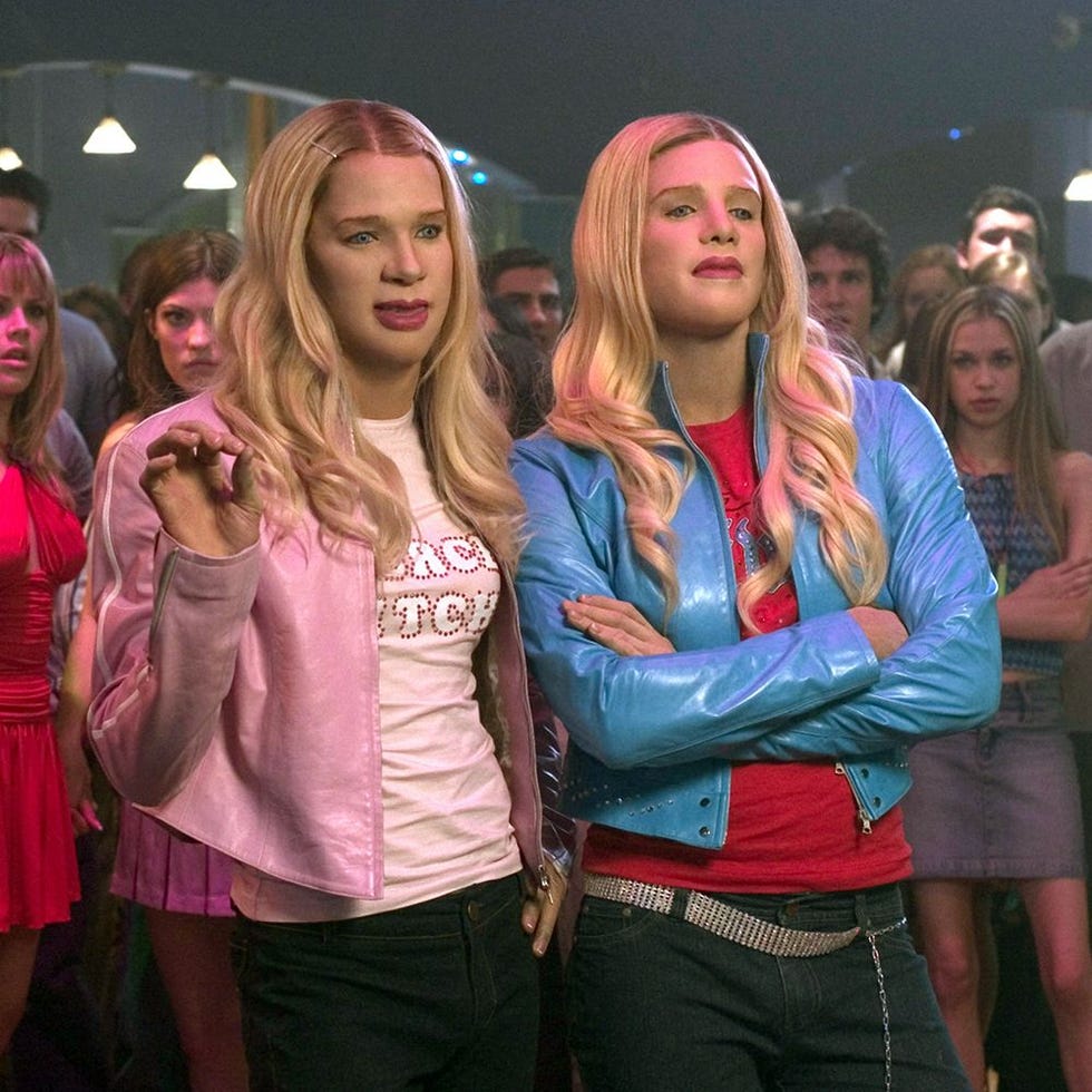 two women in a lively party atmosphere wearing colorful jackets