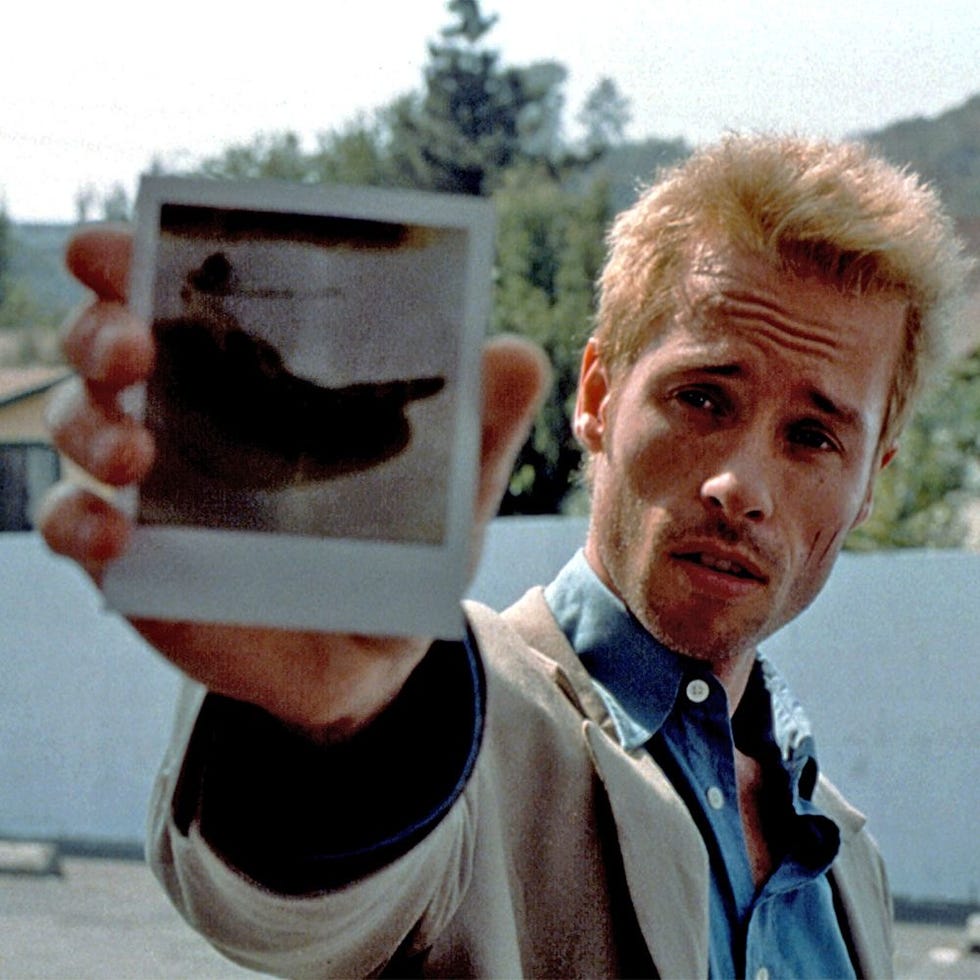 individual displaying a polaroid photograph outdoors