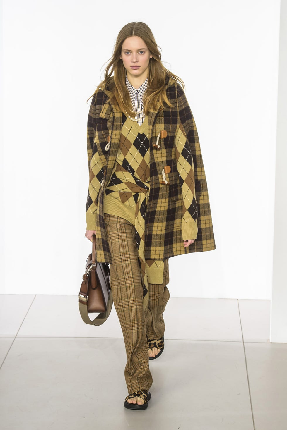 Clothing, Fashion model, Fashion show, Fashion, Outerwear, Poncho, Khaki, Runway, Pattern, Tartan, 